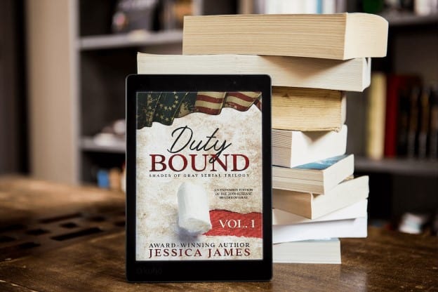 the book cover of duty bound leaning against a stack of books.