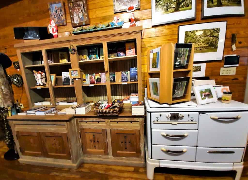 The gift shop at Laura Plantation shows an antique white cabinet and wooden cabinet full of gift items.