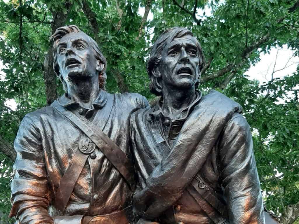 A Gettysburg monument showing two soldiers in bronze looking distressed.