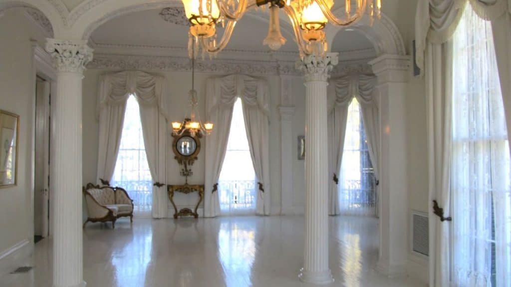 The stunning white ballroom at Nottoway features white pillars, white walls, white drapes and white chandeliers.