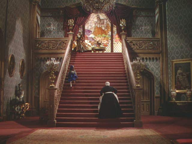 A vintage photo from the movie Gone with the Wind, showing Mammy going up the red carpeted stairs.