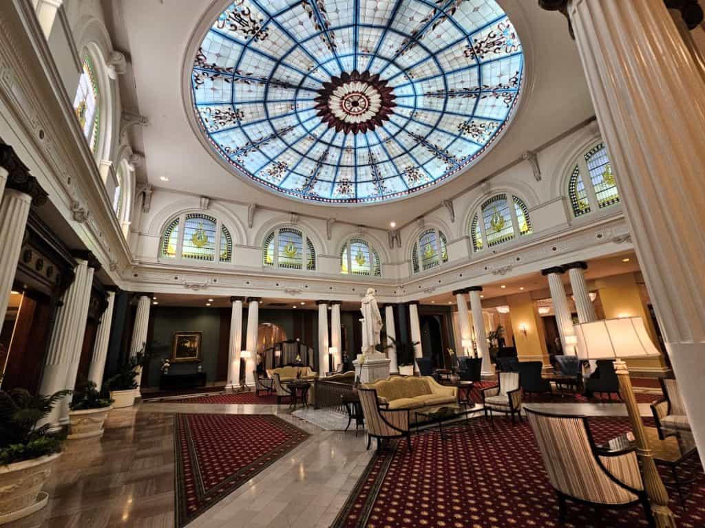 The stained glass dome in the lobby of The Jefferson Hotel, with numerous sitting areas beneath.