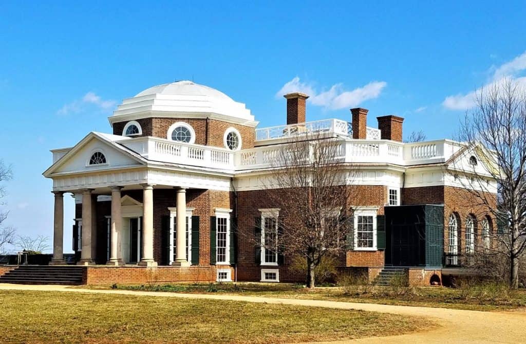 The home of Thomas Jefferson, Monticello is a brick building with a white dome and portch.
