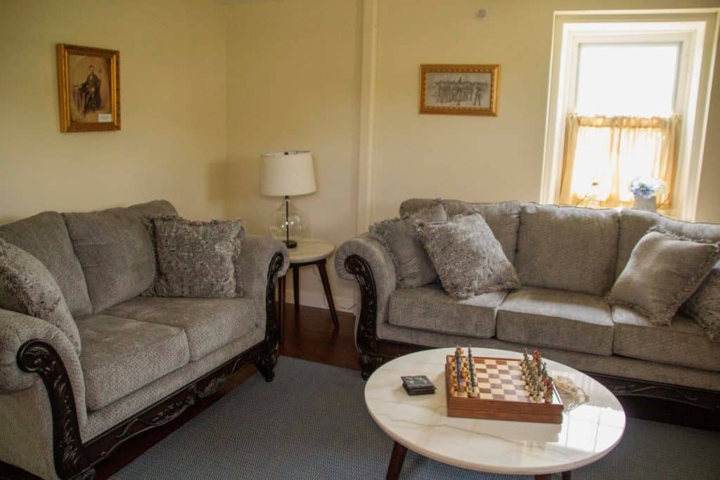 The Slyder House living room with two couches and a white round table in the middle with checkers.