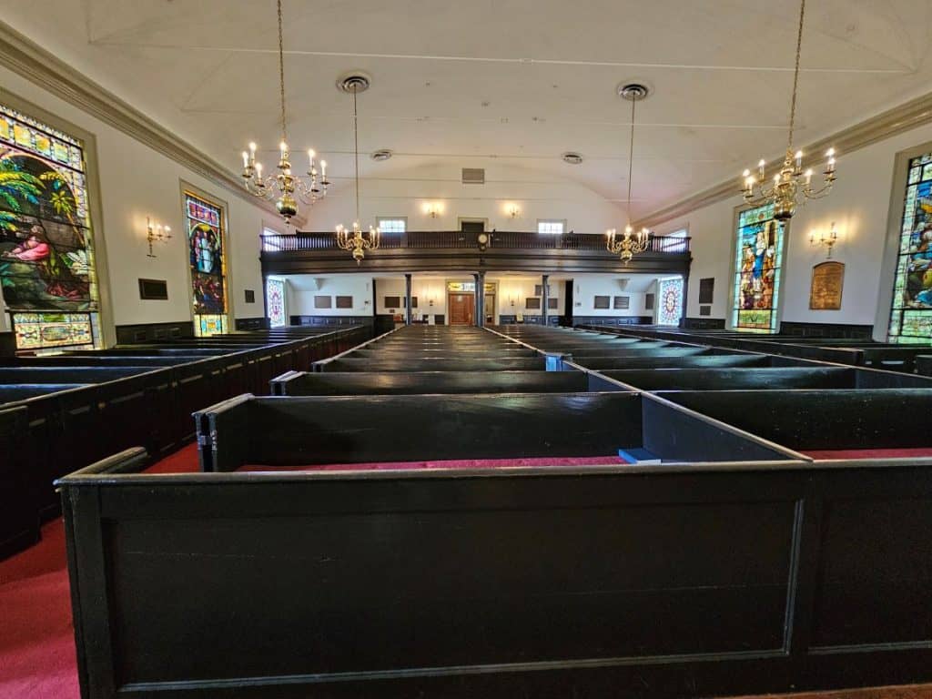 Rows of dark wooded pews at St Johns Church in Richmond.