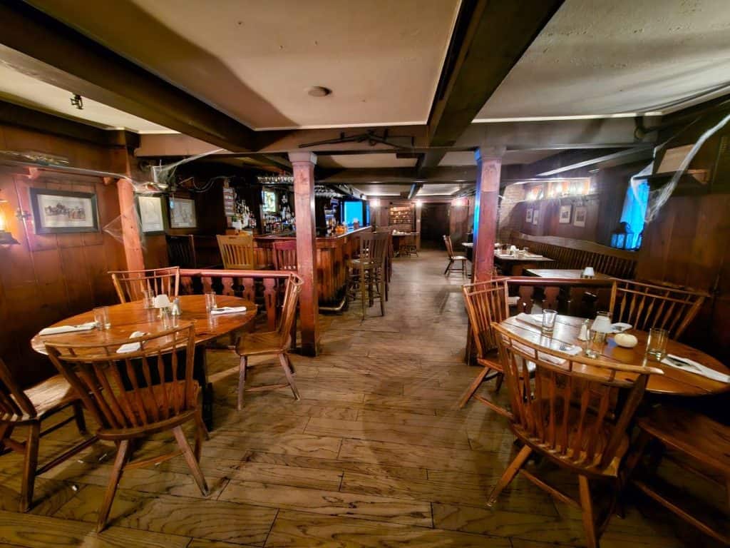 The cozy bar and restaurant at the Beekman Arms Inn with wooden beams and a wooden bar.