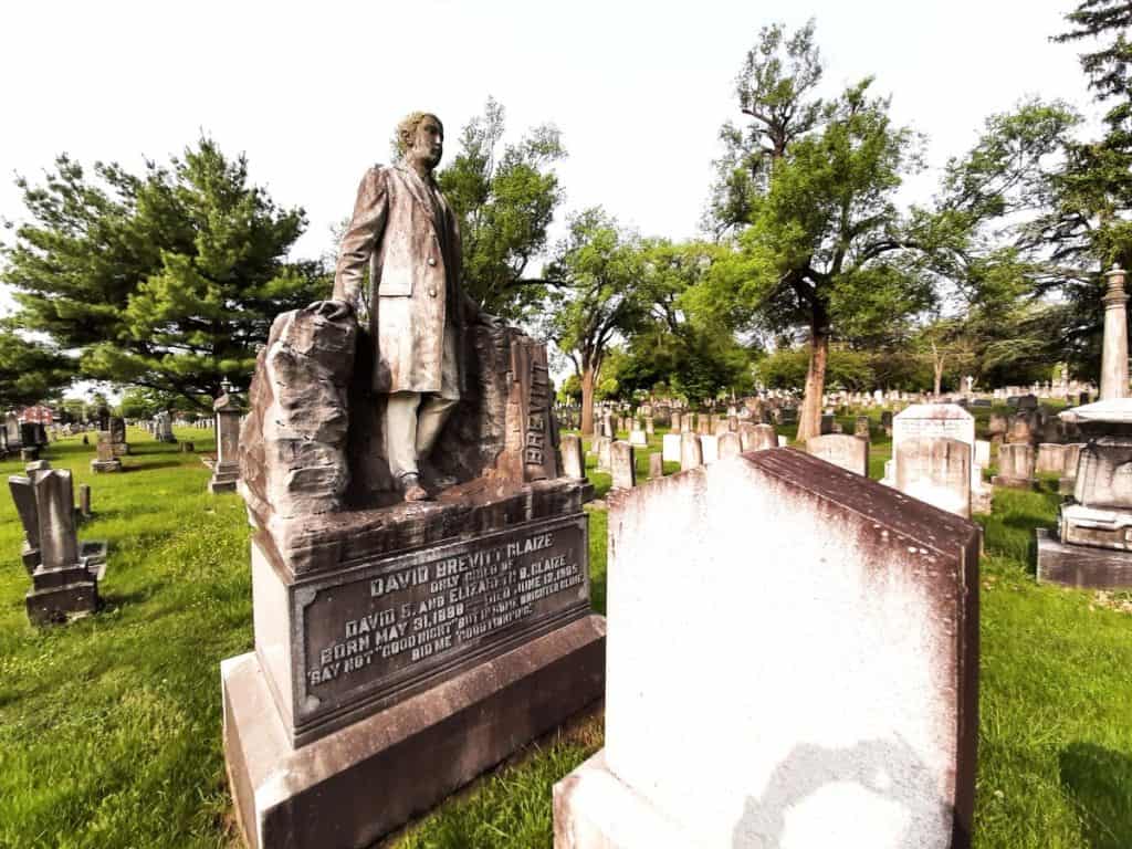 Old gravesite with statue of a man in Mount Hebron Cemetery.