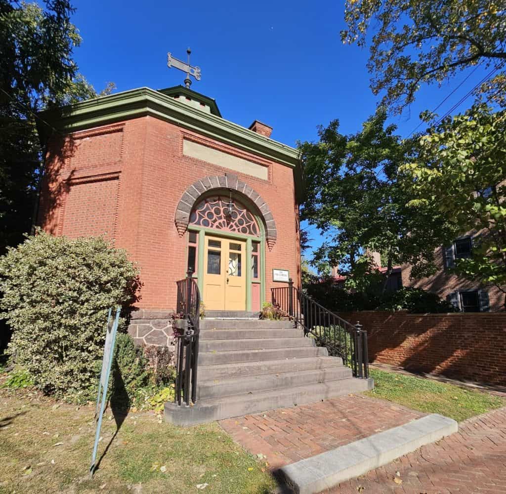 The old library in historic New Castle DE is a one story brick buildings with yellow doors.