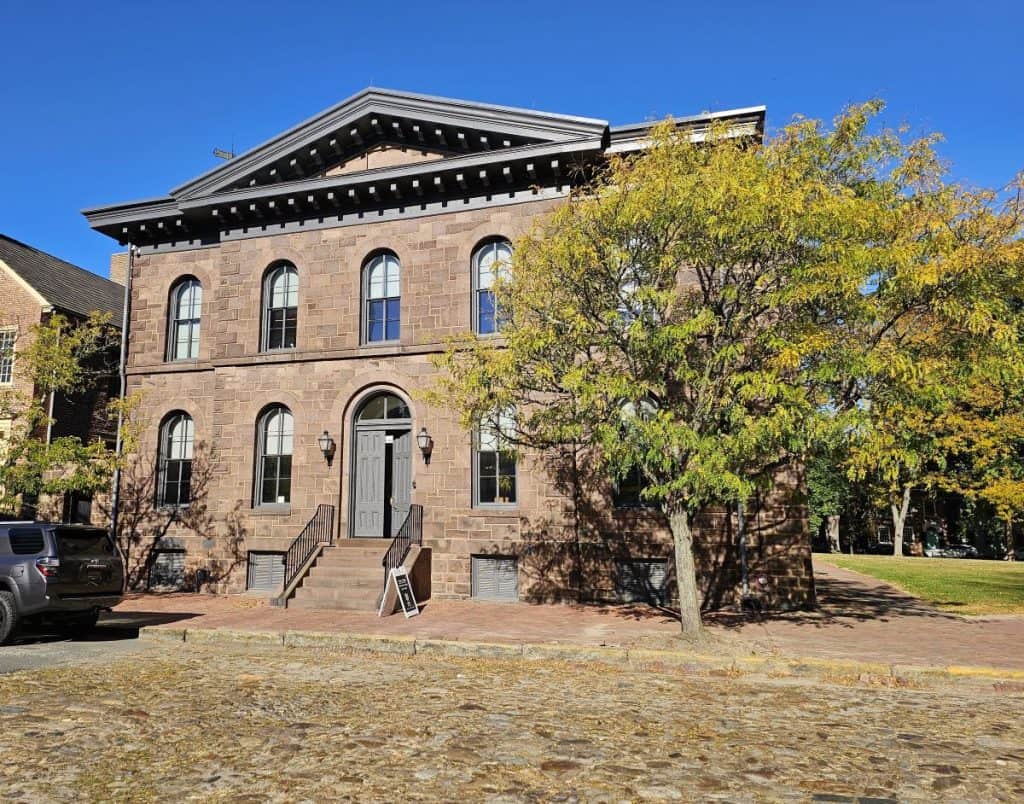 The county jail in New Castle DE is a two story brick building with arched windows.