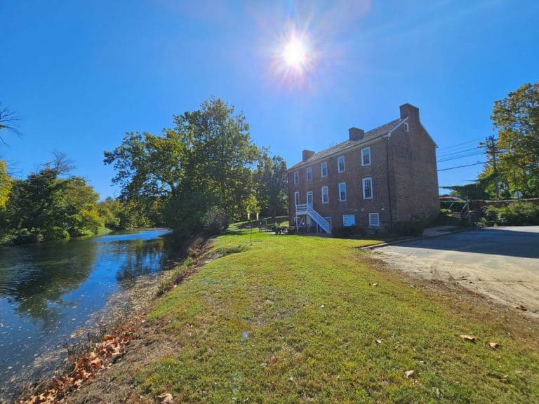 The Hale-Byrnes House a Revolutionary War landmark, is a three story brick building. It is sitting under a blue sky, with the sun shining above.