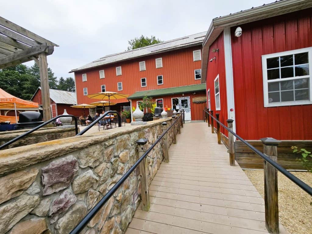A red barn with a walkway that leads to the Adams County WInery.