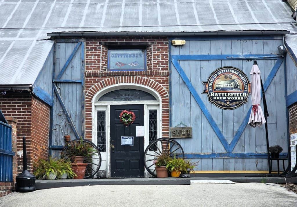 A blue barn door with a round sign that says Gettysburg Brew Works.