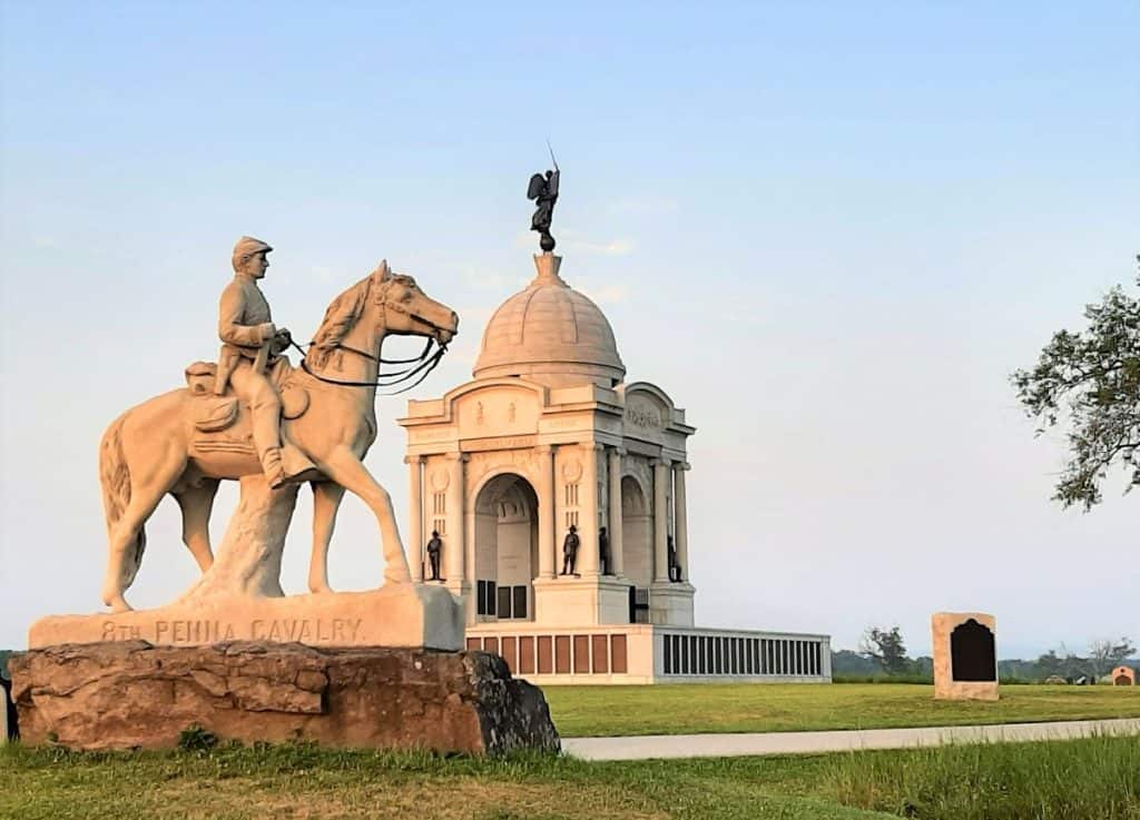The Pennsylvania Monument is in the background with the 5th PA cavalry monument, showing a rider on a horse in the foreground.