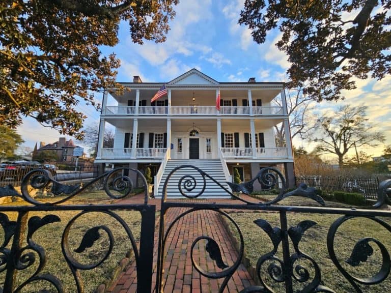 The Burgwin-Wright House in Wilmington NC is a two-story white house behind a black wrought iron gate.