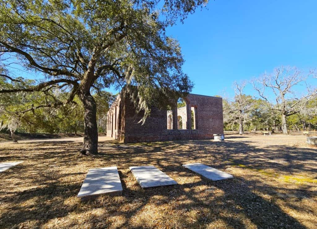 The brick walls of St. Philip's Anglican Church are all that remain of the pre-Revolutionary War building. The walls are pictured with flat gravestones in the foreground.