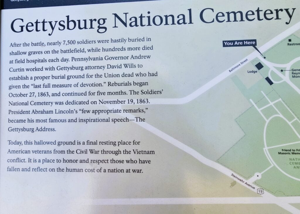 A sign that says Gettysburg National Cemetery and describes its history and is the site of the annual Gettysburg Memorial Day events.