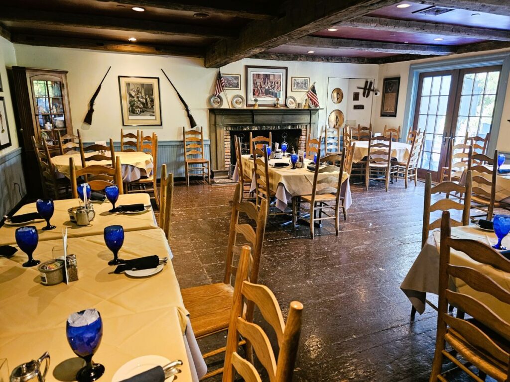 Event space in the Revolutionary War tavern Old '76 House with wooden floors and tables set up a large room.