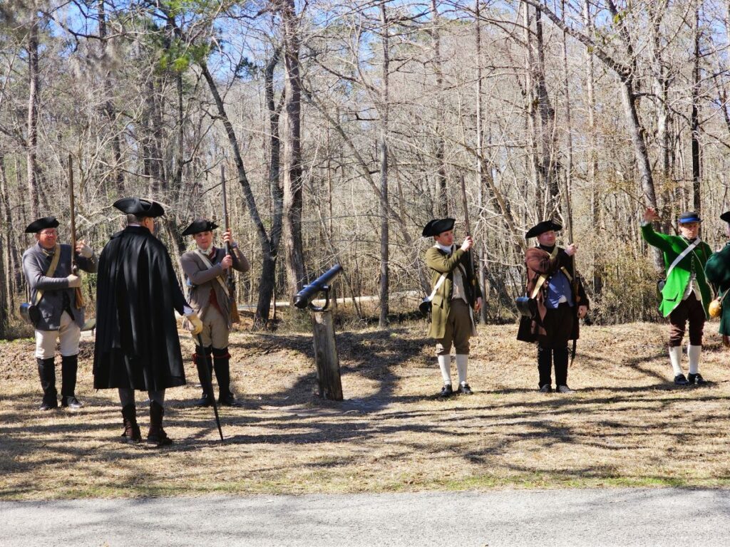 Moore's Creek Bridge Battlefield is one of the hidden gems recommended as one of the top America 250 travel destinations. Soldiers stand by a cannon after a colonial battle reenactment.