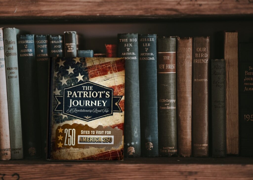 A red white and blue book called A Patriot's Journey sits on a bookshelf with other books.