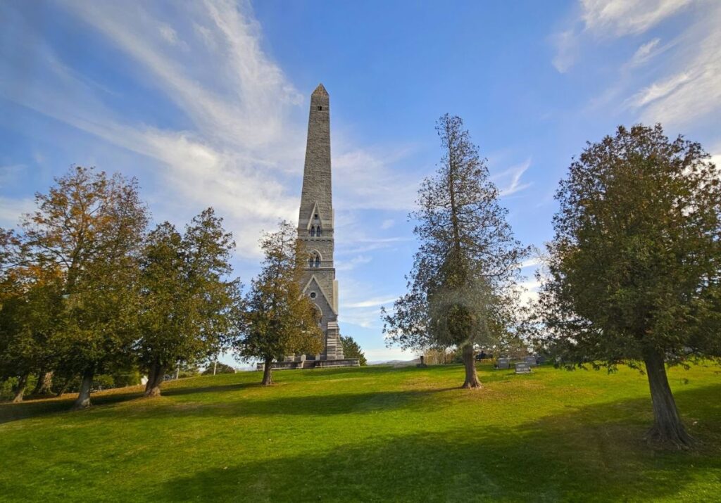 A tall monument against a blue sky is the Revolutionary War monument in Saratoga.