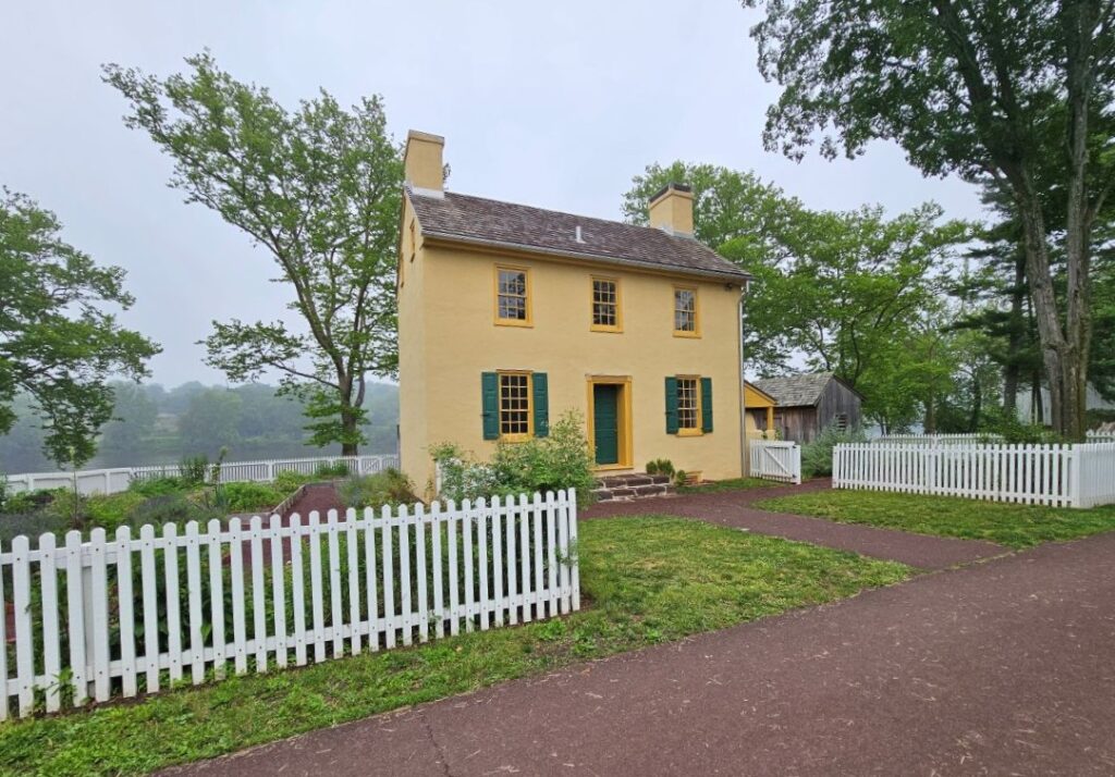 A yellow house with a white picket fence in Washington Crossing.
