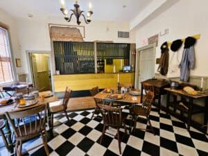 One of the historic taverns in Virginia the Hanover Tavern, with checkerboard floor, wooden tables and yellow bar area.