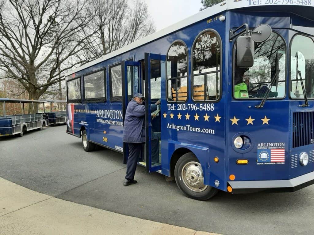 A blue hop on and off bus that takes visitors to Arlington.